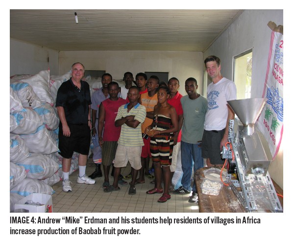 Penn State professor and student with village residents receiving pulp processor